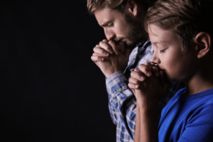 praying father and son